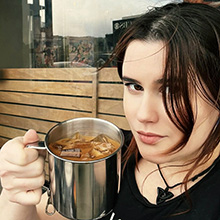 Ali Crimson headshot with heart-shaped sunglasses and fingerless gloves